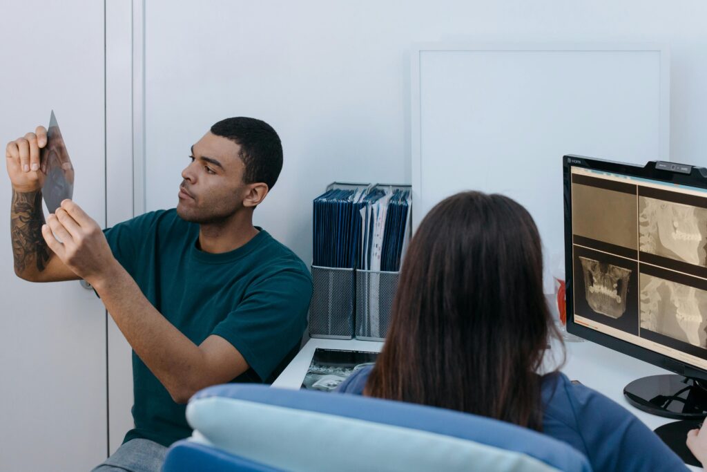 Two dental professionals reviewing X-rays in a modern clinic setting.
